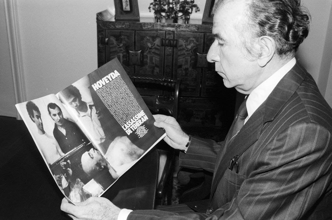 فریدون هویدا به عکسی از جنازه برادرش امیرعباس هویدا در سردخانه که در یک مجله فرانسوی منتشر شده، نگاه می‌کند.

*امیرعباس هویدا در ۱۸ فروردین ۱۳۵۸ اعدام شد.